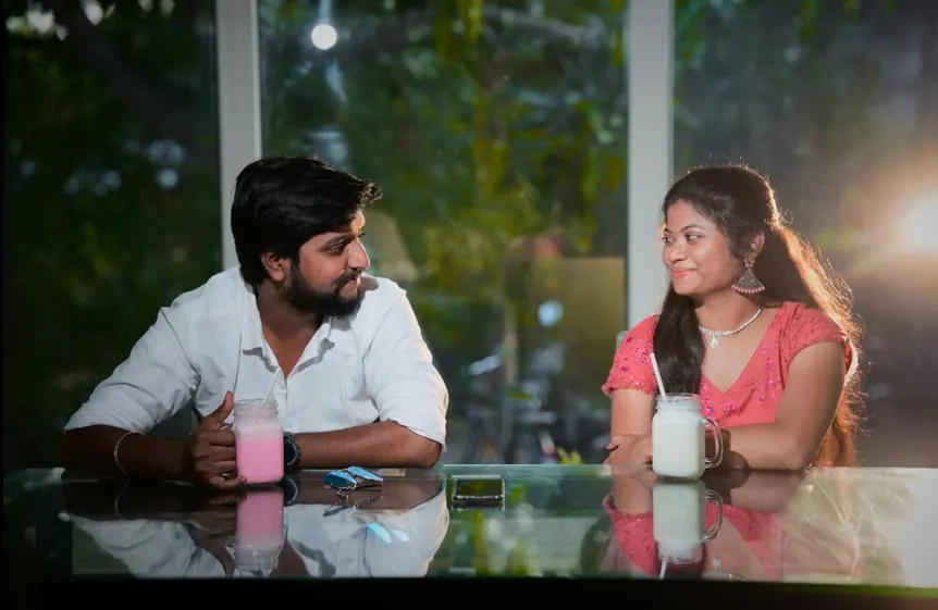 Couple seated at a café table, backlit by afternoon light