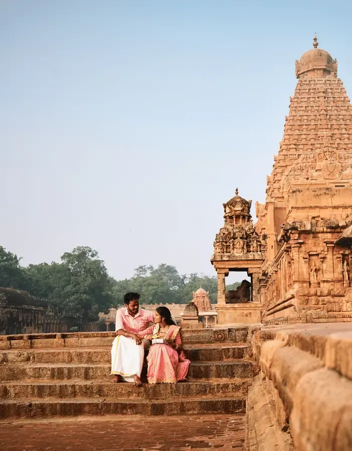 Couple seated on the stone steps of the Thanjavur Big Temple for a pre-wedding portrait